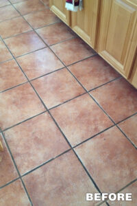 Red-toned ceramic floor tiles with visible grime—before tile cleaning service in Tucson.