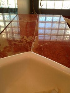 Deep-cleaned red marble floor near tub—Tucson marble tile restoration services.