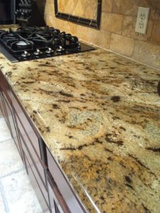 Close-up of speckled granite countertop around stove—Tucson granite restoration experts.